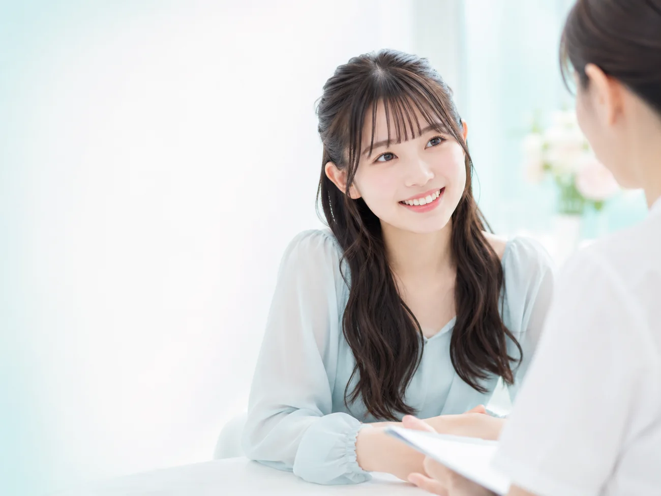 ホワイトニングについて相談する若い日本人女性