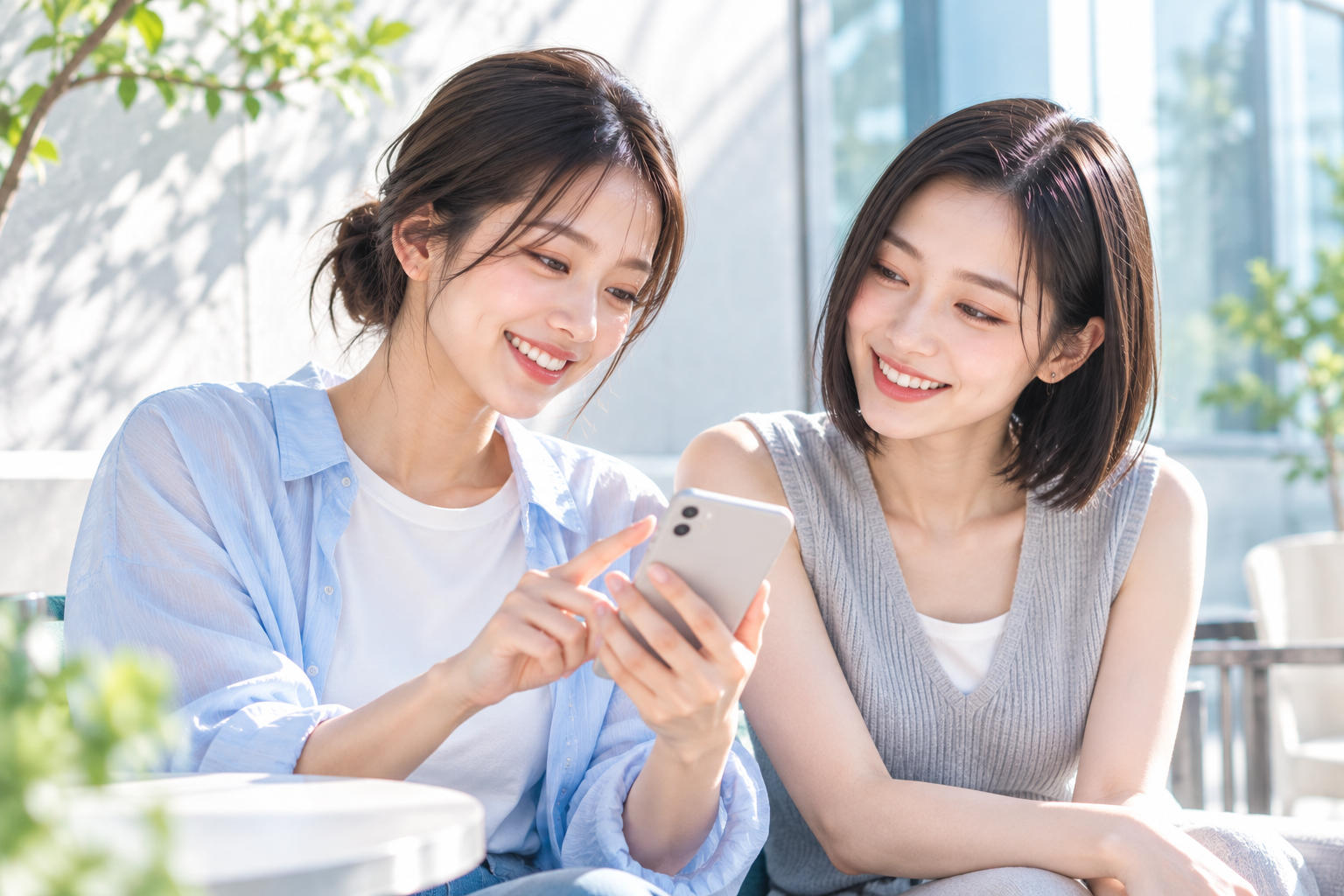 スマートフォンを見ながら笑顔で話す2人の女性