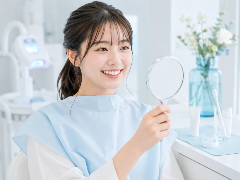 鏡で施術後の白さを確認する女性