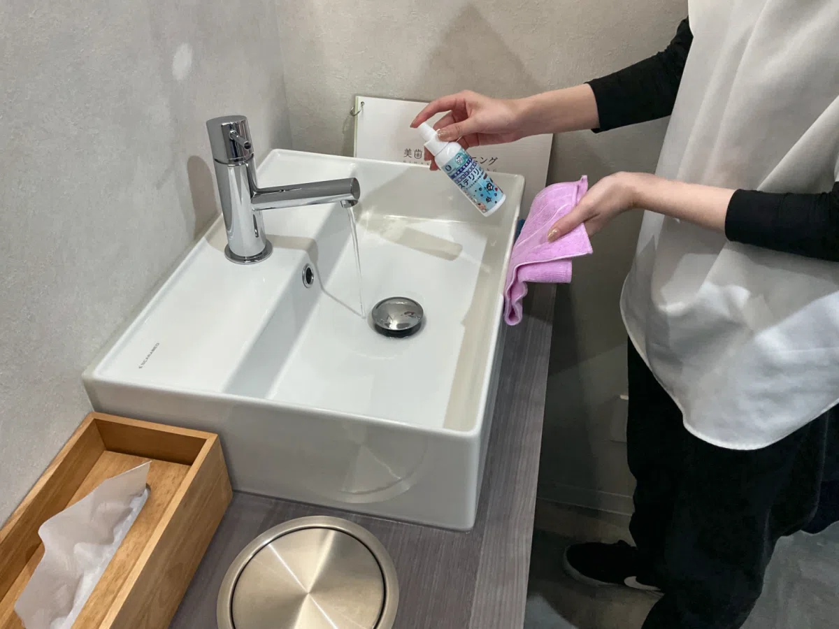 使用後の洗面台を清掃し除菌している様子
